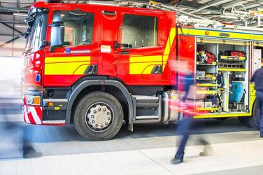 Blurred firefighters in motion in front of a fire engine at Chester Fire and Rescue