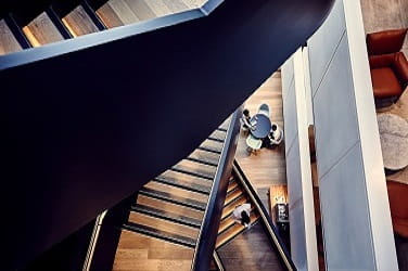 Wooden staircase, photographed from above, within modern office building