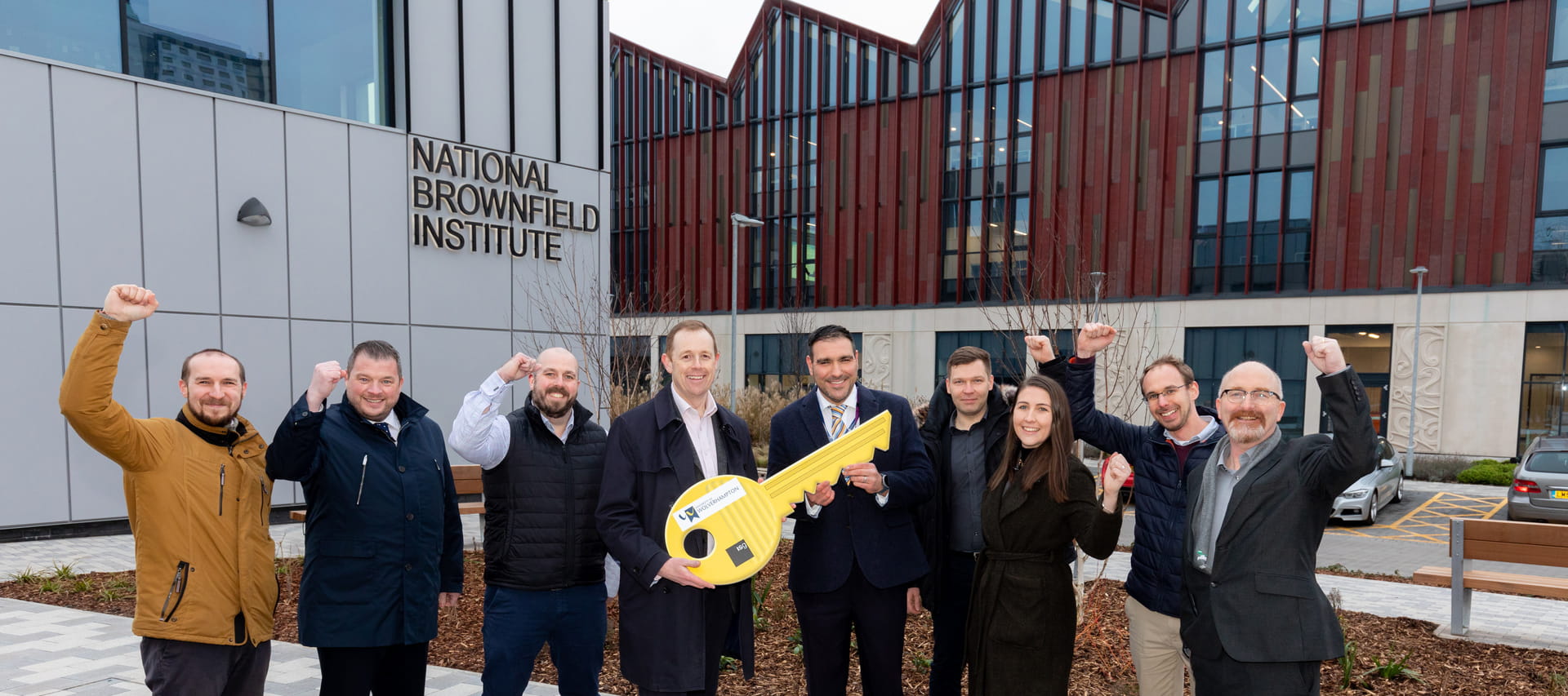 Team of people celebrating the handover of the National Brownfield Institute