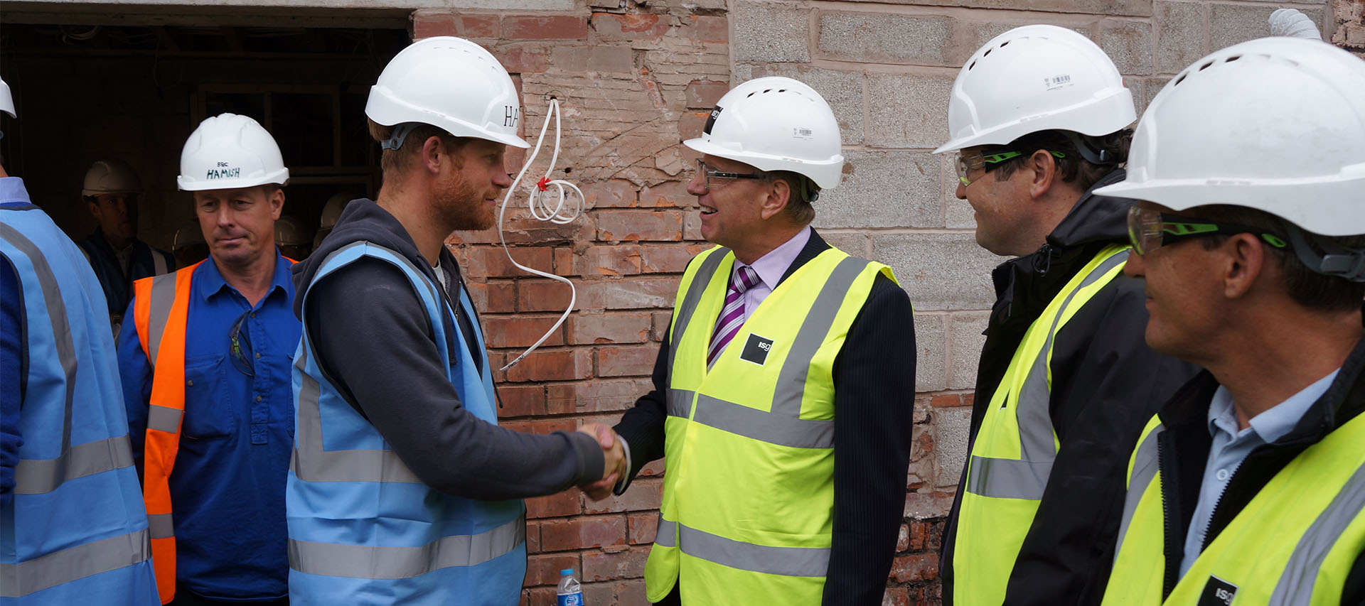 Neil Walker and Prince Harry shaking hands on a building site 