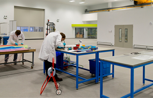 Interior University of Sheffield Advanced Manufacturing Research Centre two technicians in lab coats next to work benches