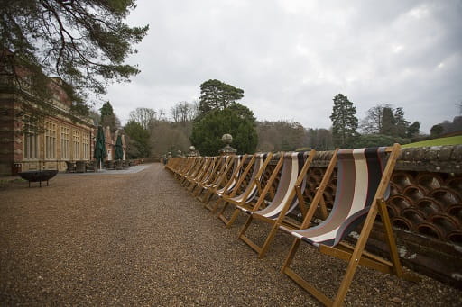 Photograph of a line of deck chairs outside a country hotel