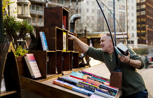 A man collecting books from a stall