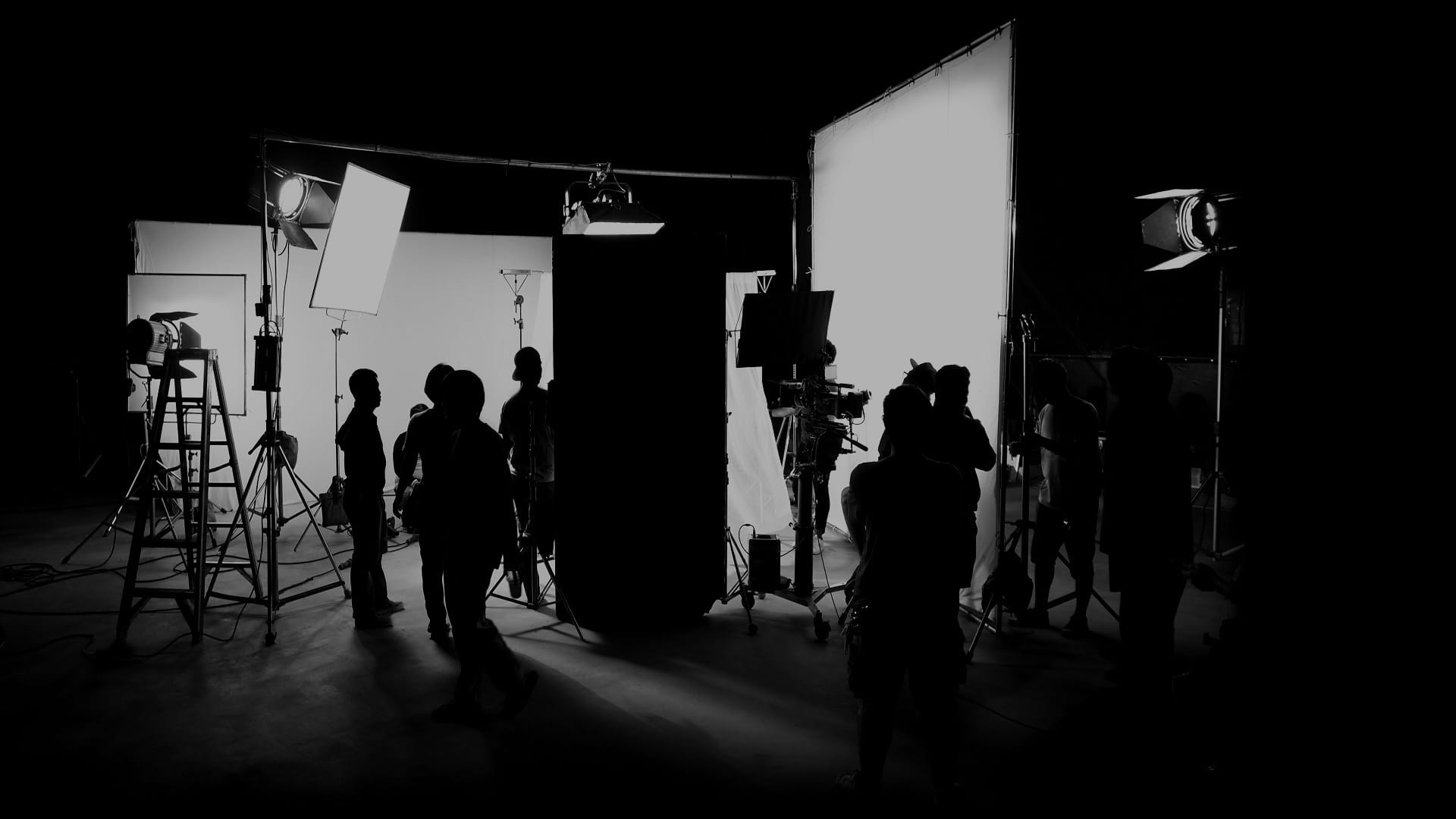 Back and white photo of silhouetted group of people working in a film studio
