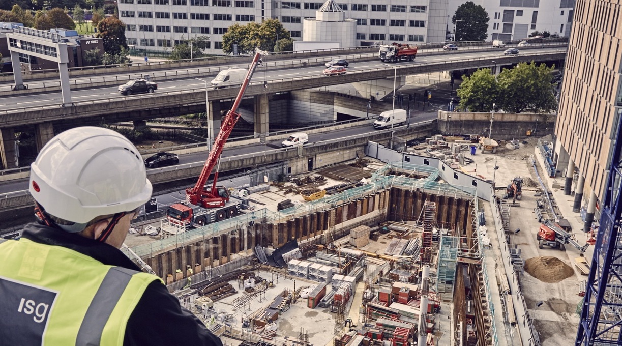 Photograph of a construction worker looking out over a city construction site