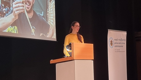 Lady stood on stage presenting 