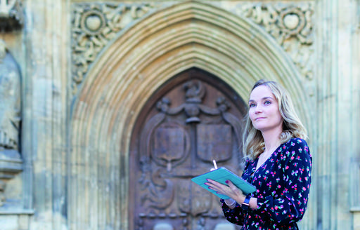 Carmel Jones, Architect, Hotel indigo Bath UK standing in front of an old door looking at clipboard