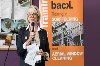 ISG employee speaking at Bounce Back with poster about training in scaffolding and window cleaning