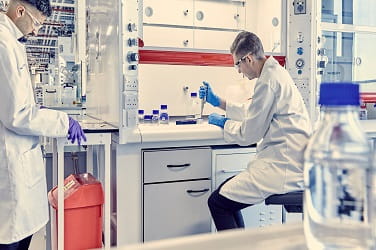Two lab technicians testing samples within a pharmaceutical laboratory 