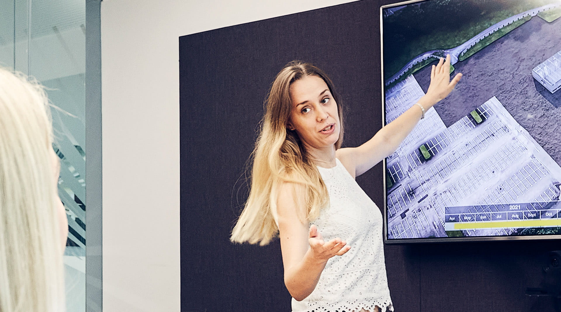 Female ISG employee giving a presentation with aerial image of a construction site