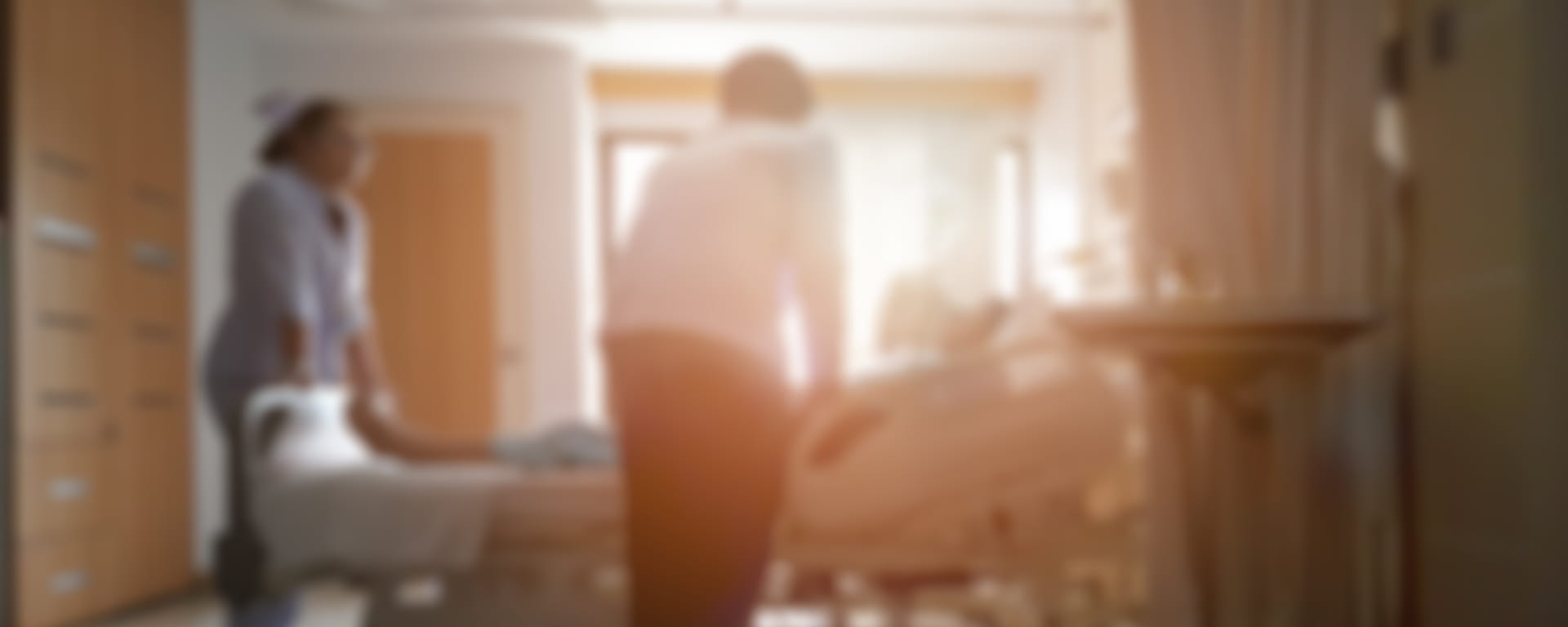 Blurred photograph of doctors and nurses around a hospital bed