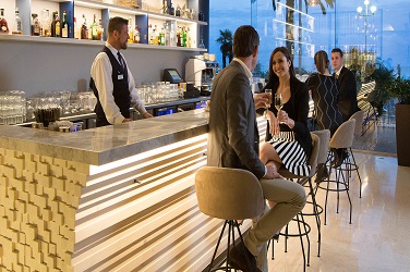 Guests sitting on bar stools at a modern bar area in a retail hospitality and leisure facility delivered by ISG