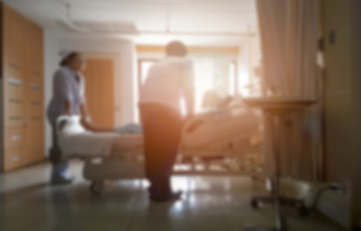 Blurred photograph of doctors and nurses around a hospital bed