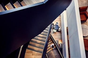 Wooden staircase, photographed from above, within modern office building
