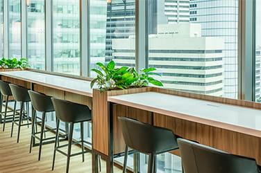 Breakfast bar with stools at a window overlooking the city in a modern office fit out by ISG for a financial services company