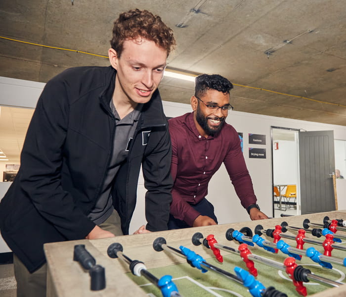 Photograph of two young guys playing foosball 