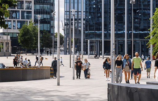 A group of people pass through Cardiff Central Square. 