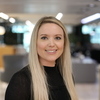 Headshot of ISG design manager Charlotte Meeks with long blonde hair and a black top smiling